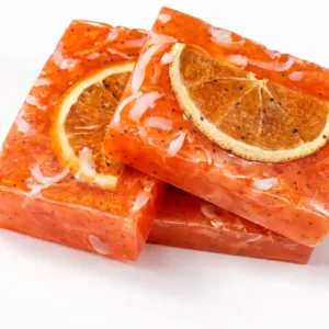 Three handmade grapefruit soap bars with natural ingredients and citrus slices on white background