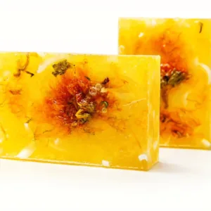 Handmade natural vanilla soap bar with dried flowers on white background