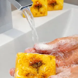 Hand washing with Handmade natural vanilla soap bar creating rich foam under running water
